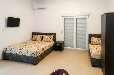 a small bedroom with two beds and a tv at Apartments Lejla in Dobra Voda