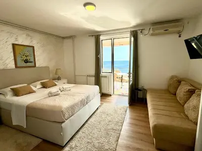 a hotel room with a bed and a couch at Apartments Kentera LUX in Sveti Stefan