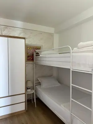 a room with two bunk beds and a table at Apartments Kentera LUX in Sveti Stefan