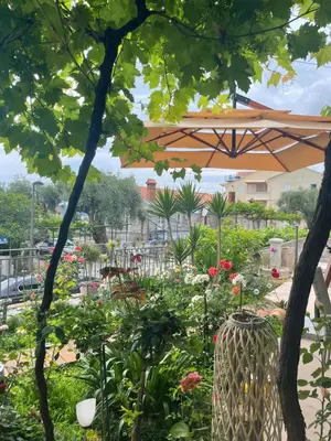 a garden with flowers and an umbrella at Apartments Kentera LUX in Sveti Stefan