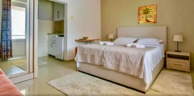 a bedroom with a large bed with towels on it at Apartments Kentera LUX in Sveti Stefan