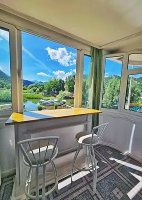 a bar with two chairs and a view of a river at Apartments FLORA and boat cruising in Virpazar