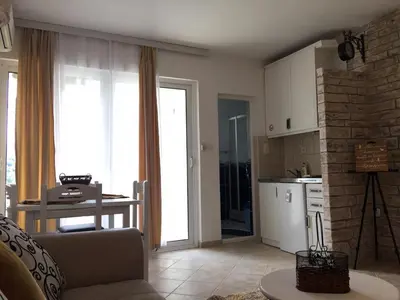 a kitchen with a couch and a table and a kitchen with a counter at Apartments FLORA and boat cruising in Virpazar
