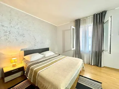 a bedroom with a large bed and a window at Apartments HMD in Budva