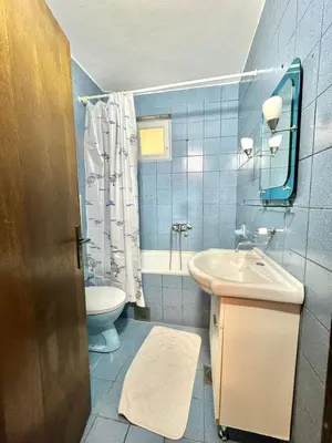 a blue bathroom with a sink and a toilet at Apartments HMD in Budva