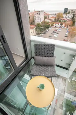 a table and a chair in a room with a window at Royal Gardens Paradise in Budva