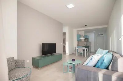 a living room with a couch and a tv at Royal Gardens Paradise in Budva