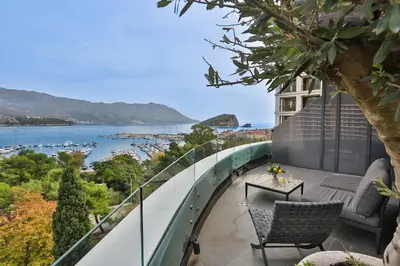 a balcony with chairs and a view of the water at Royal Gardens Paradise in Budva
