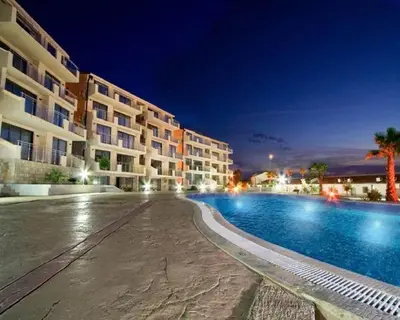 a large hotel with a swimming pool at night at Luxury Pool Apartments near the sea in Sveti Stefan