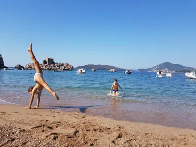 two women playing in the water on the beach at Luxury Pool Apartments near the sea in Sveti Stefan