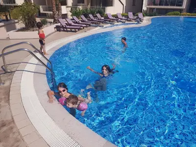 a group of children playing in a swimming pool at Luxury Pool Apartments near the sea in Sveti Stefan