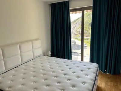 a bedroom with a bed and a large window at Luxury Pool Apartments near the sea in Sveti Stefan