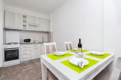 a kitchen with a table with a bottle of wine on it at Apartment Sidro in Petrovac na Moru