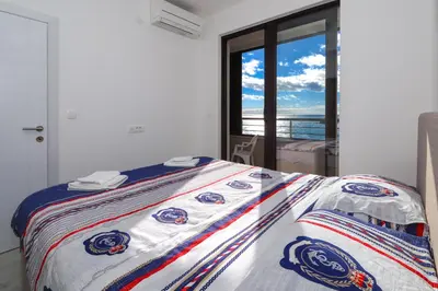 a bed in a room with a view of the ocean at Apartment Sidro in Petrovac na Moru