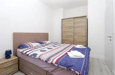 a bedroom with a bed and a wooden cabinet at Apartment Sidro in Petrovac na Moru