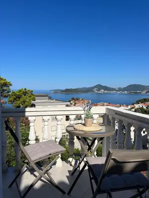 a table and chairs on a balcony with a view of the water at Apartments Aleksandar in Sveti Stefan