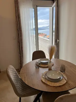 a dining room table with a view of the ocean at Apartments Aleksandar in Sveti Stefan