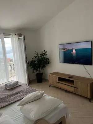 a bedroom with a flat screen tv on a wall at Apartments Aleksandar in Sveti Stefan