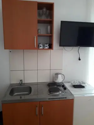 a kitchen with a sink and a stove and cabinets at Apartments Budva Center in Budva