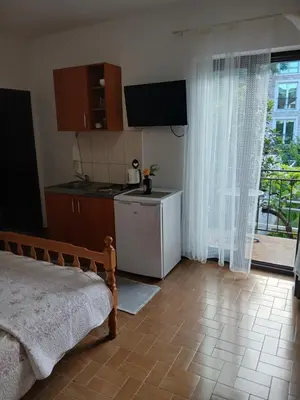 a room with a kitchen with a bed and a window at Apartments Budva Center in Budva