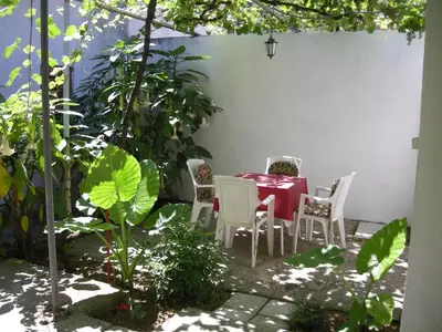 a red table and chairs in a patio with plants at Apartments Budva Center in Budva