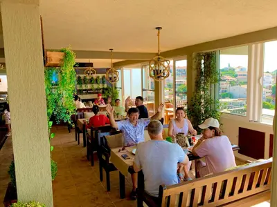 a group of people sitting at tables in a restaurant at Apartments Tati in Ulcinj
