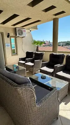 a patio with wicker furniture and a glass table at Apartments Tati in Ulcinj