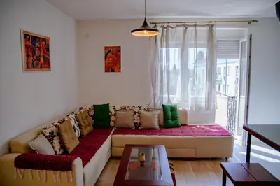 a living room with a couch and a window at Peaceful City Center in Podgorica