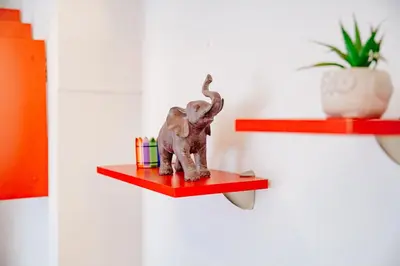 a toy elephant on a red shelf on a wall at Peaceful City Center in Podgorica