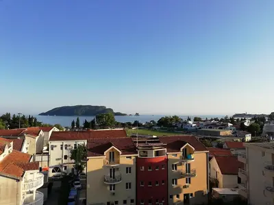 a city with buildings and the ocean in the background at Apartments Marković in Budva