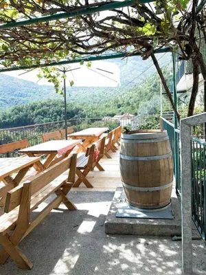 a group of wooden tables and a barrel on a deck at Apartments 