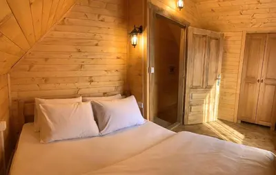 a white bed in a room with a wooden wall at Apartments 