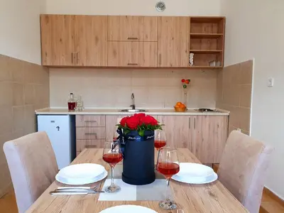 a table with two glasses of wine and red flowers at Apartments 