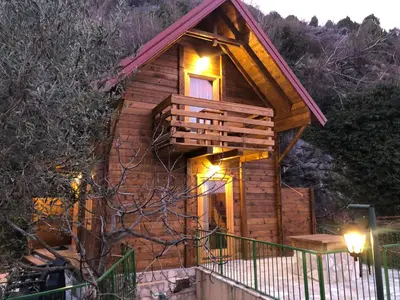 a small wooden cabin with lights on the porch at Apartments 