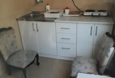 a small kitchen with a sink and a chair at Guest House Olga in Budva