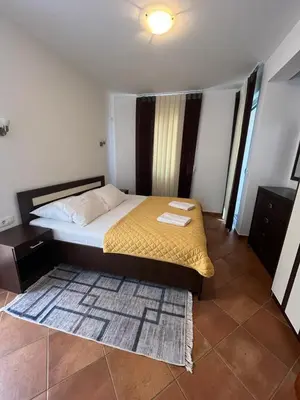 a bedroom with a large bed with a yellow blanket at Apartments Palma in Dobra Voda