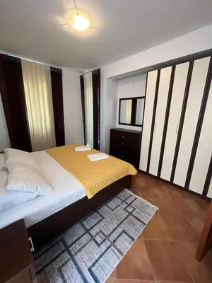 a bedroom with a bed with yellow sheets and a rug at Apartments Palma in Dobra Voda