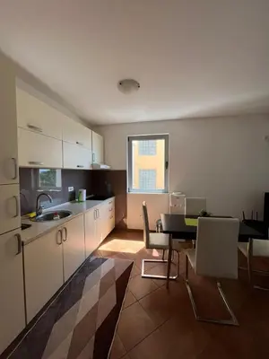a kitchen and dining room with a table and chairs at Apartments Palma in Dobra Voda