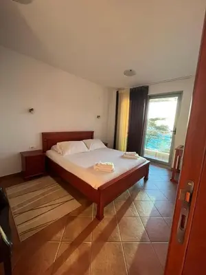 a bedroom with a bed and a large window at Apartments Palma in Dobra Voda