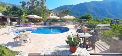 a patio with a pool and tables and chairs at Vila Pegaz in Virpazar
