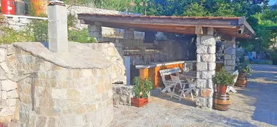 a stone patio with a bench and a stone wall at Vila Pegaz in Virpazar