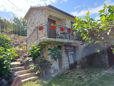 a stone house with a balcony and stairs at Vila Pegaz in Virpazar