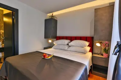 a bedroom with a bed with a bowl of fruit on it at Hotel M in Podgorica