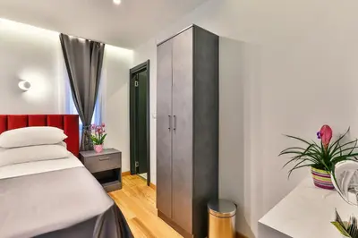 a bedroom with a bed and a cabinet at Hotel M in Podgorica
