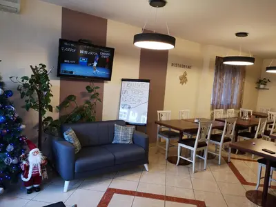 a restaurant with a christmas tree and tables and a couch at Hotel M in Podgorica