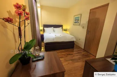 a hotel room with a bed and a table with flowers at Hotel M in Podgorica