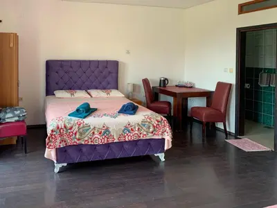 a bedroom with a purple bed and a table and chairs at Villa Dulsinea in Ulcinj