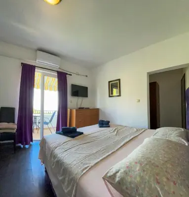 a bedroom with a large bed and a sliding glass door at Villa Dulsinea in Ulcinj