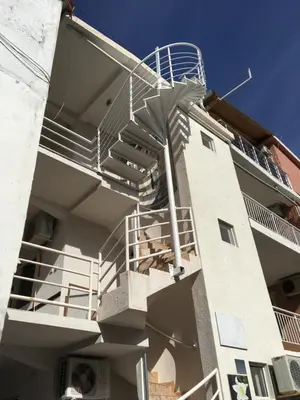 a building with a spiral staircase on the side of it at Sobe Krin - Smestaj Canj in Čanj