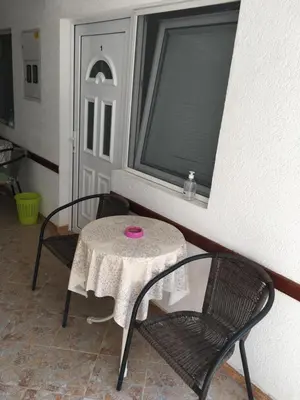 a table and chairs with a pink plate on it at Sobe Krin - Smestaj Canj in Čanj